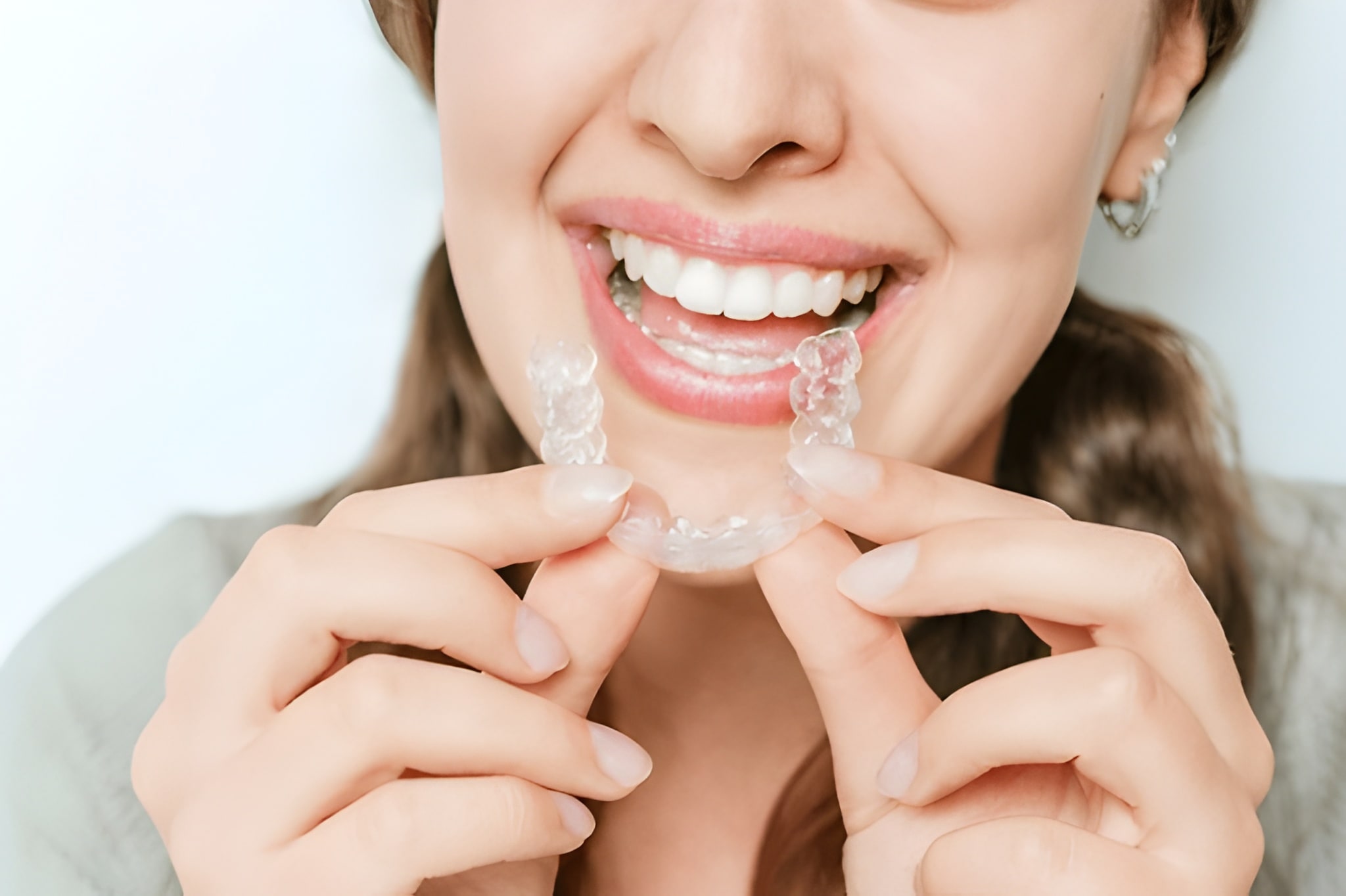 Clear aligners in Flower Mound TX close-up view of patient applying aligner tray for orthodontic treatment at Supreme Smiles Dentistry